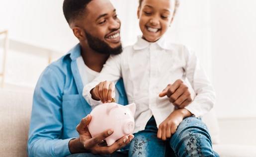 A father and daughter saving money in a piggy bank