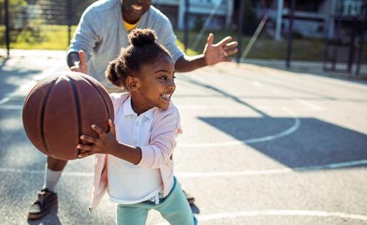 一位父亲和他的女儿在打篮球